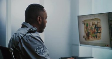 Havalimanı Güvenlik Kontrol Noktası: Modern Yazılım kullanarak bavulları kontrol eden Afro-Amerikan Ulaşım Güvenliği İşçisi. Metal dedektör X-ray Makinesinde bagaj tarama prosedürleri.