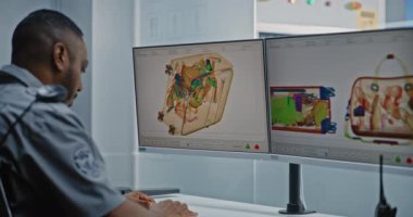 Havalimanı Güvenlik Kontrol Noktası: Modern Yazılım kullanarak bavulları kontrol eden Afro-Amerikan Ulaşım Güvenliği İşçisi. Metal dedektör X-ray Makinesinde bagaj tarama prosedürleri.