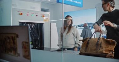 Havaalanı Güvenlik Kontrol Noktası: Röntgen makinesinde taramadan sonra bavul alan çeşitli yolcular. Metal dedektörüyle bagaj taraması için gelişmiş yazılımı görüntüleyen Bilgisayar Monitörüne Odaklan.