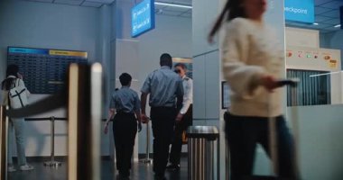 Kalabalık Uluslararası Havaalanı Terminali 'nde bavullu çeşitli yolcular. Profesyonel Hava Yolları Pilotu ve Bavullu İki Uçuş Görevlisi Güvenlik Kontrol Noktasından Geçiyor.