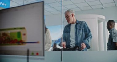 Havaalanı Güvenlik Kontrol Noktası: Teftiş sırasında çeşitli insanlar, el bagajlı gezginler. Modern Yazılım Biçimsel Metal Detektör Taramasının Gerçek-zamanlı X-ray görüntüleri ile Bilgisayar Ekranı.