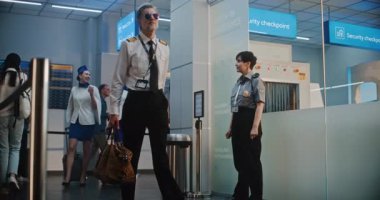 Kalabalık Uluslararası Havaalanı Terminali Uçuş Ekibi: Havayolu Kaptanı ve Ticari Uçuş Bavullarıyla Yürüyen Üniformalı İki Güzel Hostes, Güvenlik Kontrol Noktasını Geçiyor. Yavaş Hareket