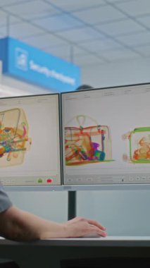 Havaalanı Güvenlik Kontrol Noktası: Kadın TSA İşçi Kontrolü X-ray Metal Detektör Tarama İşlemi Bilgisayar Monitörlerindeki Bagaj İşlemi. Bagajın tarama işlemi sırasında çeşitli turistler. Dikey Çekim.