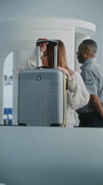 Havaalanı Terminal Kontrol Noktası: El bagajı ve el bagajları ile güvenlik kontrolü sırasında çeşitli yolcular. Monitörde gösterilen bagaj tarama X-ray Metal dedektörü ile analiz programı. Dikey Çekim.