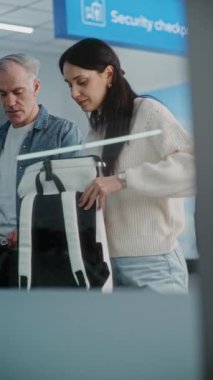 Havaalanı Güvenlik Kontrol Noktası: Gösterim sırasında bavulları taşıyan çeşitli kişiler. Bilgisayar Monitörü, X-ray Metal detektörü tarama programını görüntülüyor. Dikey Çekim.