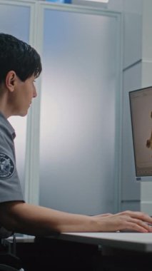 Havaalanı Kontrol Noktası: Bilgisayar Ekranları Yazılım Kullanarak Bavul X-ray taramasını izleyen kadın güvenlik subayı. Arka planda, Güvenlik kontrolü sırasında bavulları olan çeşitli insanlar. Dikey Çekim