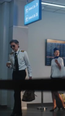 Havaalanı Terminali Uçuş Ekibi: Havaalanı Kaptanı ve Uçuş için Bavullarla Yürüyen Üniformalı İki Güzel Hostes, Güvenlik Kontrol Noktası 'nda TSA çalışanı tarafından geçiliyor. Ağır çekim. Dikey Çekim.