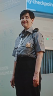 Havaalanı Terminali: Olgun Havayolu Pilotu ve Üniformalı İki Güzel Uçuş Görevlisi Ticari Uçuş Sonrası Bavulla Yürüyüş, Bayan Güvenlik Subayının yanından geçiyoruz. Ağır çekim. Dikey Çekim.