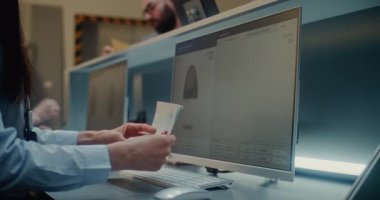 Havaalanı kontrol gişesi, havayolu ajanının kontrol belgeleri, havaalanı terminalinde uçak bileti. Biniş Uçuşu Yolcusunun Parmak İzi Taraması ve Biyometrik Verisi Analiz Ediliyor.