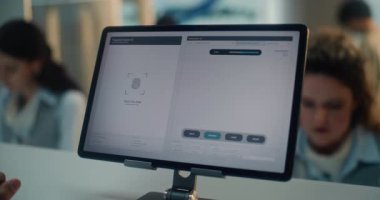 Havaalanı kontrol gişesi: Hintli Turistin Parmak izi taraması için dokunmatik ekranı kapatması. Uçuş için Yolcu Biyometrik Verilerini Kontrol Etmek için Dijital Tablet Programı. Havaalanı Terminali.