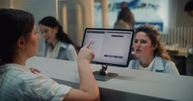 Havaalanı kontrol gişesi: Kadın Havayolu Ajanı Yolcu Biyometrik Uçuş Verilerini Kontrol Etti. Kadın Parmak İzi Taramasından Tanımlamak için Dokunmatik Ekrana Parmak Koyuyor. Uluslararası Havaalanı Terminali