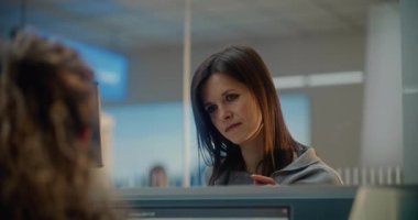 Havaalanı check-in sayacı: Yüz Tanıma Taramasıyla Kadın Biyometrik Verileri Doğruluyor. Bayan Havayolu Ajanı Yolcuya Belge ve Bilet Veriyor. Uluslararası Havalimanı Terminalinde Pasaport Denetimi