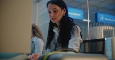 Havaalanı sayacı: Bayan Havayolu Check-in Görevlisi Bagaj Etiketi Barkodunu Uçağa binmek için Bavula Koyuyor. Uluslararası Havaalanı Terminalinde Müşteri Hizmetleri ve Güvenlik Bagajı Kontrolü.