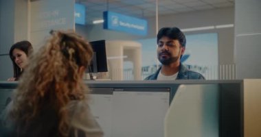 Havaalanı kontrol gişesi: Hintli Adam Pasaport Veriyor ve Uçuş Biletini Havayolu Ajanı, Kadın İşçi Bilgisayarda Yolcu Kişisel Verilerini Kontrol Ediyor. Uluslararası Havalimanı Terminalinde Pasaport Denetimi