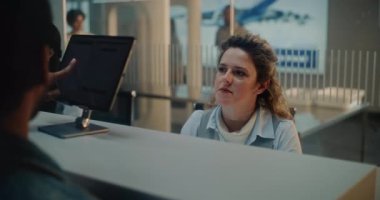 Havaalanı kontrol gişesi: Bayan Havayolu Ajanı Yolcu Biyometrik Verilerini Uçuş için kontrol ediyor. Kızılderili adam parmak izi taraması için dokunmatik ekranda parmak izi arıyor. Uluslararası Havaalanı Terminali.