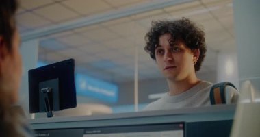 Havaalanı kayıt gişesindeki genç adam: Bayan Havayolu Ajanı Belgeleri Kontrol Ediyor, Yolcuya Pasaport ve Uçuş Kartı Veriyor. Uluslararası Havaalanı Terminalinde Müşteri Hizmetleri ve Pasaport Denetimi.