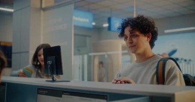 Havaalanı kontrol gişesi: Genç Adam Kimlik Tanıma Taramasıyla Kimlik Verilerini Doğrulayarak Havayolu İşçisine Belge Veriyor ve Uçak Biletini Veriyor. Uluslararası Havalimanı Terminalinde Pasaport Denetimi.