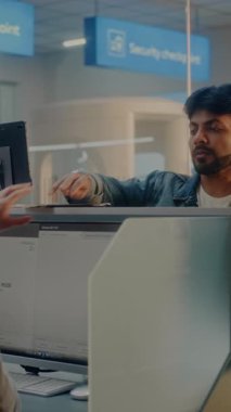 Check-in sayacındaki yolcular: Bayan Havayolu Ajanları Belge ve Uçak Biletlerini Kabul Ediyor, Bilgisayarlardaki Biyometrik Verileri Kontrol Ediyor. Uluslararası Havalimanı Terminali 'nde pasaport kontrolü. Dikey Çekim.