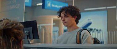 Havaalanı kontrol gişesi: Genç Adam Yüz Tanıma Taramasından Kimliğini Onayladı, Kadın Havayolu Ajanı Uçuş Yolcusunun Biyometrik Verilerini Kontrol Etti. Havaalanı terminalinde pasaport kontrolü. Yavaş Hareket.