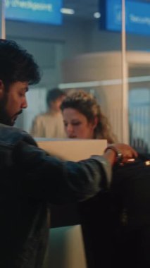 Hintli Adam Biyometrik Tarama için pasaport ve bilet veriyor, Bagaj kontrolü için bavul yerleştiriyor, Kimlik Biyometrik Taraması için parmağını dijital tablete koyuyor. Havaalanındaki güvenlik kontrol noktası. Dikey Çekim