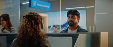 Havaalanı kontrol gişesi: Hintli adam yüz tanıma taramasıyla kimlik bilgilerini doğruluyor. Yolcuya pasaport ve biniş kartı veren kadın havayolu işçisi. Uluslararası Havaalanı Terminali.