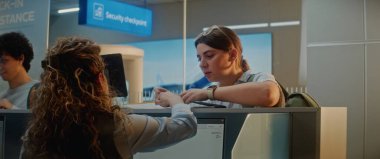 Havalimanı Kontrol gişesindeki çok ırklı yolcuların kuyruğu: Kadın Havayolu İşçi Kontrol Belgeleri ve Uçak Biletleri. Uluslararası Havalimanı Terminalinde Pasaport Kontrolü Sırasındaki Çeşitli Turistler.