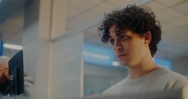 Havaalanı check-in gişesindeki çeşitli yolcular: Uluslararası Havalimanı Terminali 'nde Kimlik Verisini Yüz Tanıma Taramasıyla Doğrulayan, Pasaport Kontrolü sırasında Havayolu İşçisiyle Konuşan Genç Adam.