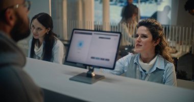 Havaalanı kontrol gişesi: Kadın havayolu işçisi, uçuş için kişisel kimlik bilgilerini kontrol ediyor. Biyometrik Parmak izi taraması için Dokunmatik Ekrana Parmak Koyan Adam. Uluslararası Havaalanı Terminali.