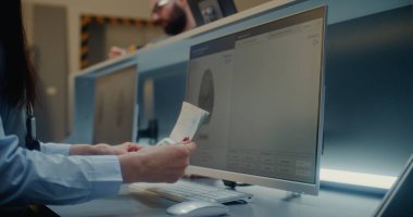 Havaalanı kontrol gişesi, havayolu ajanının kontrol belgeleri, havaalanı terminalinde uçak bileti. Biniş Uçuşu Yolcusunun Parmak İzi Taraması ve Biyometrik Verisi Analiz Ediliyor.