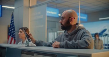 Havaalanı check-in sayacı: Man Giving Documents and Airplane Ticket to Airline Agent, Finger on Touch Screen to Documents by Scanning Fingerprint. Havaalanı Terminalinde Pasaport Denetimi