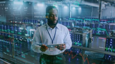 VFX ile Geleceğin Büyük Veri Merkezi: Afro-Amerikan Yöneticisi Dijital Tablet Kullanıyor. Sunuculardaki İnternet Trafiğinin Animasyon Diyagramları. Bilgi Teknolojisi, Dijitalleştirme Konsepti. Orta Çekim.