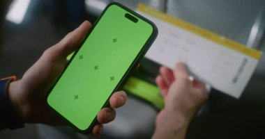 Havaalanı Terminali: Yolcu Yeşil Kroma Anahtarlı Akıllı Telefon kullanarak Uçuş Geçidi Biletini Tarayarak Havayolu Merkezinin Salonunda Oturuyor. Uygulama Arayüzü için Yer Tutucu ile Görüntü Şablonu.