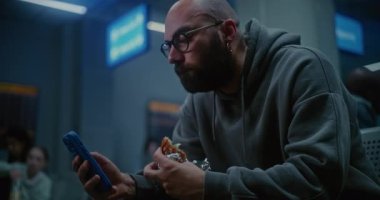 Gece Havayolları İnbotu 'nun Yatılı Salonu İnsan Yiyen Burger ve Kaydıran Akıllı Telefon. Kalabalık Uluslararası Havaalanı Terminalinde oturan Yolcu, Tatil Uçuşu için Gecikmiş Uçak Bekliyor.