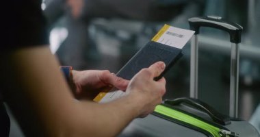 Uluslararası Havalimanı Terminali: Yolcunun Kapanışı Hava Yolları İnbotu 'nun Kalkış Salonunda Bavulla Oturuyor, Pasaportu Biniş Kartıyla Bekliyor. Gezgin Uçuşu Bekliyor, Tatile Çıkıyor.