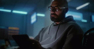 Kalabalık Uluslararası Havalimanı Terminali: Tablet Bilgisayar kullanan yorgun ve uykulu adam, Geceleri Havayolu İnbotu 'nun Yatılı Salonunda Koltuklarda Uyuyan Kadın. Çeşitli Yolcular Gecikmeli Uçuş Bekliyor.