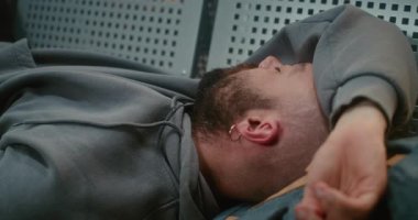 Kalabalık Uluslararası Havalimanı Terminali: Sırt çantalı Yorgun Adam 'ın Kapanışı, Yatılı Havayolu Merkezinde Koltuklarda Uyuyor. Gecikmiş Uçak Uçuşunu Bekleyen Yolcu. Turizm ve Seyahat.