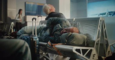 Kalabalık Uluslararası Havaalanı Terminali: Bavul ve Sırt Çantalı Yorgun Afro-Amerikan Turist Yataklı Havayolu Merkezinde Koltuklarda Uyuyor. Çeşitli Yolcular Gecikmeli Uçuş Bekliyor