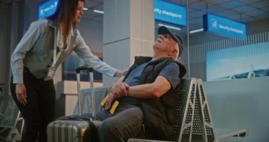 Uluslararası Havalimanı Terminali: Havayolu İnbotu 'nun Boş Biniş Salonu' ndaki koltukta uyuyan bavullu yaşlı yolcu. Havaalanı işçisi Uyanış Adamı, onu biniş kapısına götürüyor.