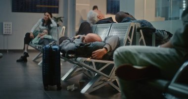 Kalabalık Uluslararası Havaalanı Terminali: Yorgun Adam ve Uçak İnbotu 'nun Yatılı Salonu' nda Koltuklarda Uyuyor. Çeşitli İnsanlar ve Yolcular Gecikmeli Uçuşu Bekliyor. Dolly Yakınlaştır