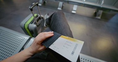 Kalabalık Uluslararası Havaalanı Terminali: Bavul, Pasaport ve Uçak Biletli Yolcu Uçak İnbotu Kalkış Salonu 'nda Oturuyor, Sonra Biniş için Kapıya Yürüyor. POV İlk Kişi Görünümü.