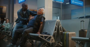 Kalabalık Uluslararası Havalimanı Terminali: Yaşlı Adam Kalp krizi geçiriyor, Infarction in Inarding Lounge of Airline Hub. Kıdemli Yolcuya Yardım Eden Çeşitli İnsanlar, Havaalanı İşçisi Tıbbi Yardım Çağrısı.