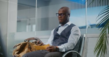 Havaalanı Terminali: Afrikalı Amerikalı Girişimci Gecikmeli Uçuş Tutma Uçak Bileti Hakkında Rahatsız Oldu, Telefonda Konuşuyor. İş adamı, Ayrılış Salonu 'nda oturuyor, iş gezisine çıkıyor. Doli Vuruşu.