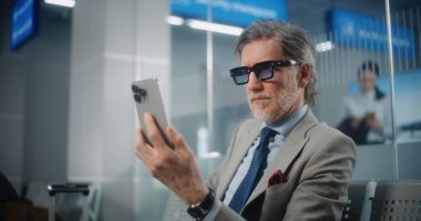 Havaalanı Terminali: Başarılı İşadamı Smartphone 'da İş Ortağıyla Konuşuyor, Video Call, Oturma Salonu. Girişimci Uçak Uçuşunu Bekliyor, Seyahate Çıkıyor. Ortam Kapalı.