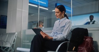 Havaalanı Terminali: Dijital Tablet Kullanmakta, E-İş Yapmakta, Uzaktan Çalışmakta, Kameraya Bakmakta Başarılı İş Kadını. Girişimci Seyahate Çıkıyor, Kalkış Salonunda Uçuş Bekliyor. Doli Vuruşu.