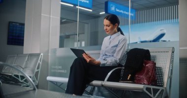 Havaalanı Terminali: Dijital Tablet Kullanmakta, E-İş Yapmakta, Uzaktan Çalışmakta, Kameraya Bakmakta Başarılı İş Kadını. Girişimci Seyahate Çıkıyor, Kalkış Salonunda Uçuş Bekliyor. Doli Vuruşu.