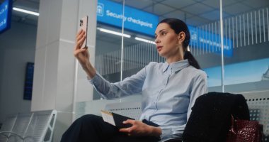 Havaalanı Terminali: Başarılı İş Kadını Akıllı Telefon 'da İş Ortağıyla Konuşuyor, Video Çağrısı, Kalkış Salonunda Uçak Bekliyor. Bayan Girişimci Seyahate Çıkıyor. Doli Vuruşu.