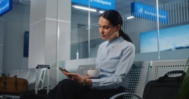 Uluslararası Havalimanı Terminali: Akıllı Telefon Kullanımı ve İçme Kahvesi Kullanımı, E-posta Yollama, Başarılı İş Kadınları. Bayan Girişimci VIP Ayrılış Salonunda Uçuşunu Bekliyor. Doli Vuruşu.