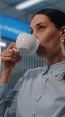 Havaalanı Terminali: VIP Ayrılış Salonu 'nda oturan ve Kahve İçen Kadın Girişimci. Başarılı bir iş kadını uçak bileti bekliyor, iş seyahatine çıkıyor. Dikey Görüntüyü Kapat.