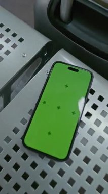 Havaalanı Terminalindeki Havayolu Lounge: Yeşil Kroma Anahtarlı Cep Telefonu Mock Up 'ı Kahve ve Bavul' un yanındaki koltukta yatarken göster. İş Reklamcılığı için Yer Tutucu ile Görüntü Şablonu. Dikey Çekim.