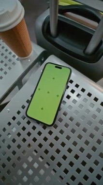 Havaalanı Terminali 'ndeki Havayolu Hub Lounge: Yeşil Chroma Anahtarlı Cep Telefonu Kahve ve Bavul' un yanındaki koltukta yatıyor. İş Reklamcılığı için Yer Tutucu ile Görüntü Şablonu. Dikey Çekim.